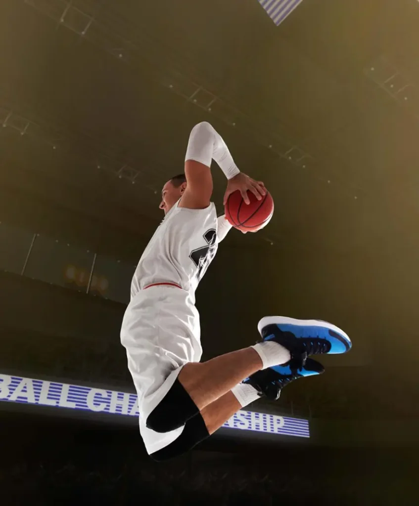 Gros plan sur un ballon de basket qui passe à travers le cerceau et le filet, mettant en valeur un moment décisif d'un match de basket professionnel.